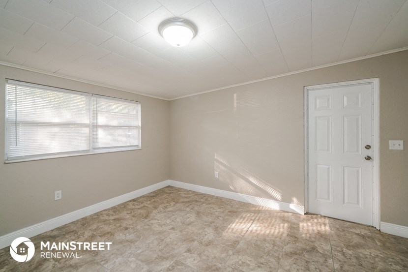 an empty room with a white door and a window