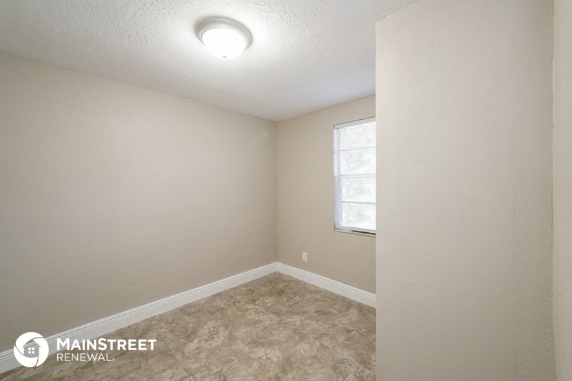 the spacious bedroom of this 2500 sq ft home has a large window and beige
