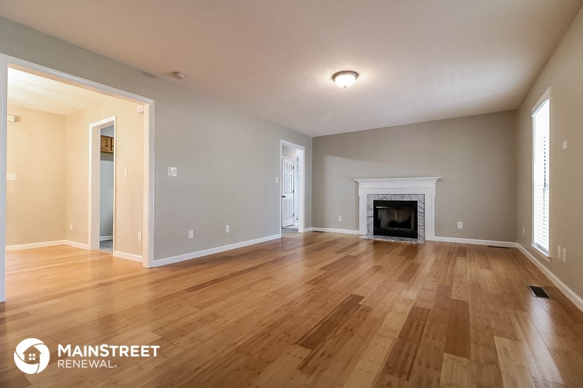 the spacious living room with fireplace and hardwood flooring
