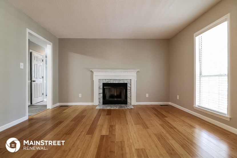 a living room with a fireplace and wooden floors
