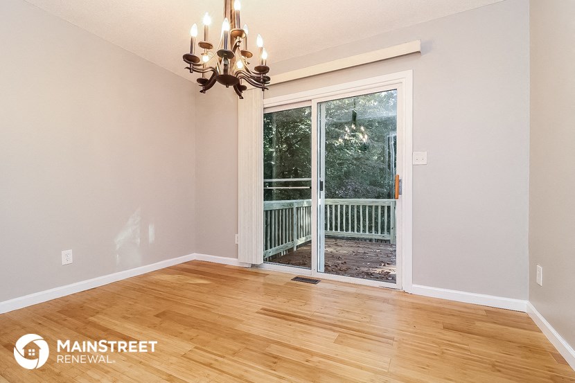 an empty living room with a sliding glass door to a balcony