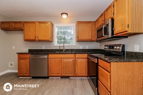 a kitchen with wooden cabinets and granite counter tops and a sink