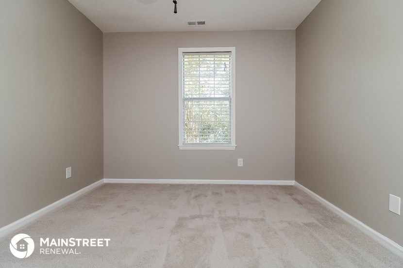 a clean empty room with a window in it