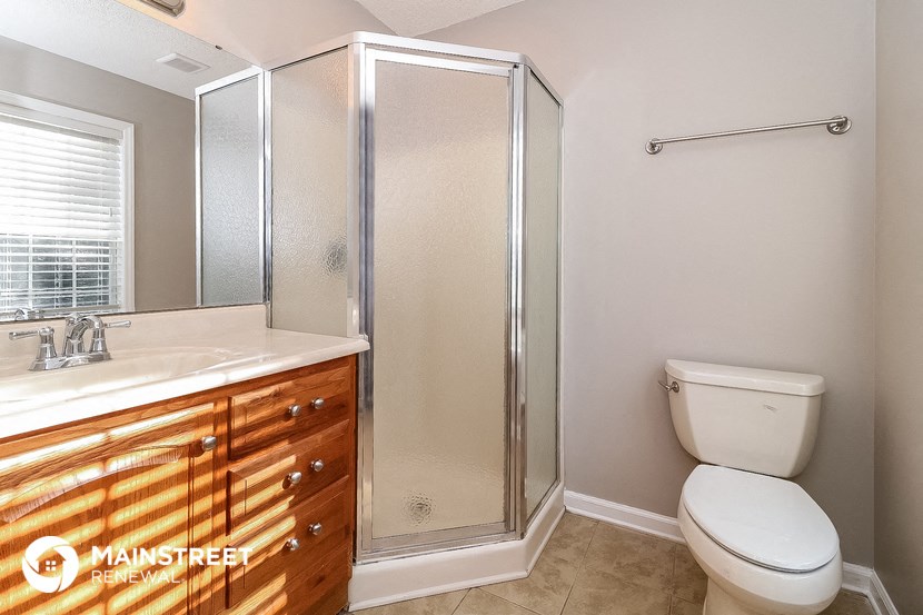 the bathroom has a shower and a sink and a toilet