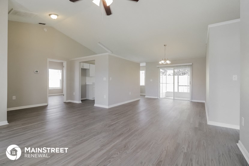 an empty living room and dining room with wood flooring