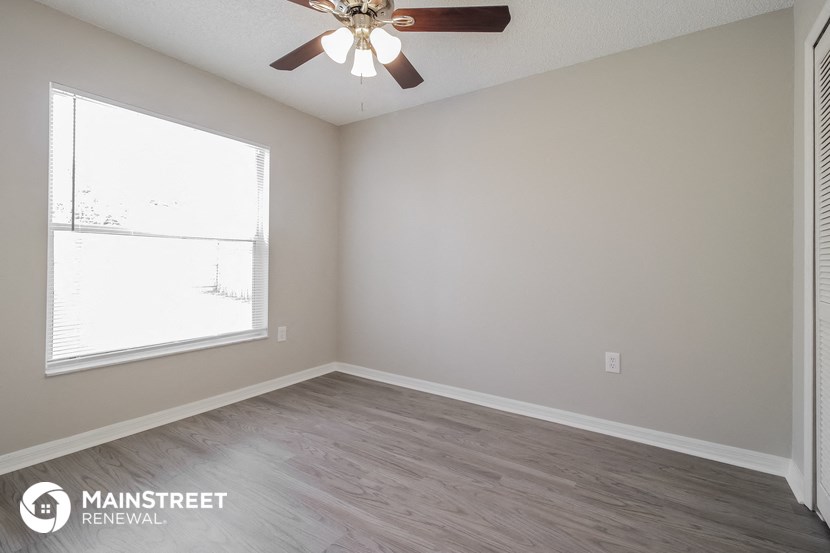 a bedroom with a ceiling fan and a window