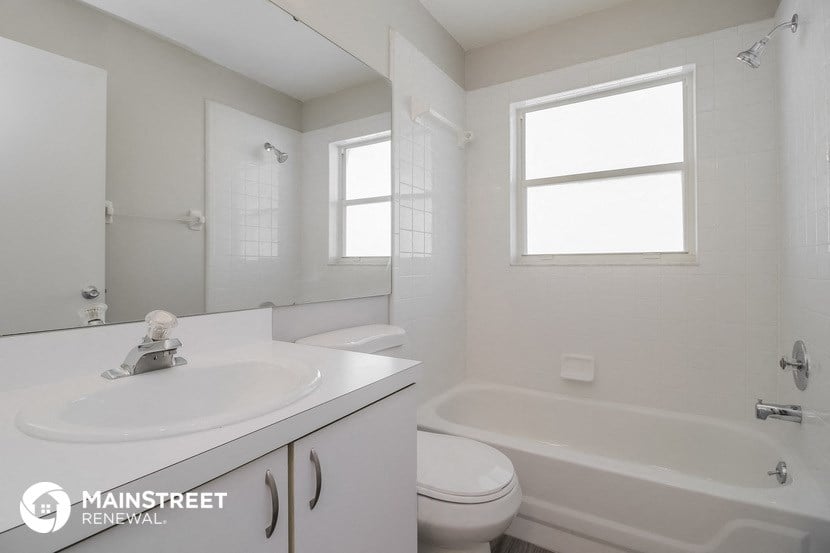 a white bathroom with a sink and a tub and a toilet