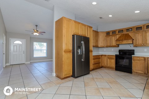 a kitchen with wooden cabinets and a black refrigerator