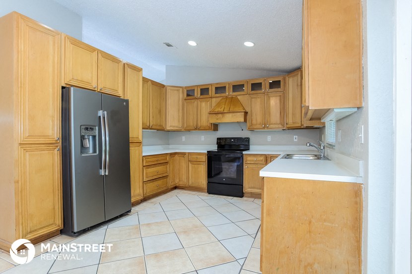 a kitchen with wooden cabinets and a black refrigerator
