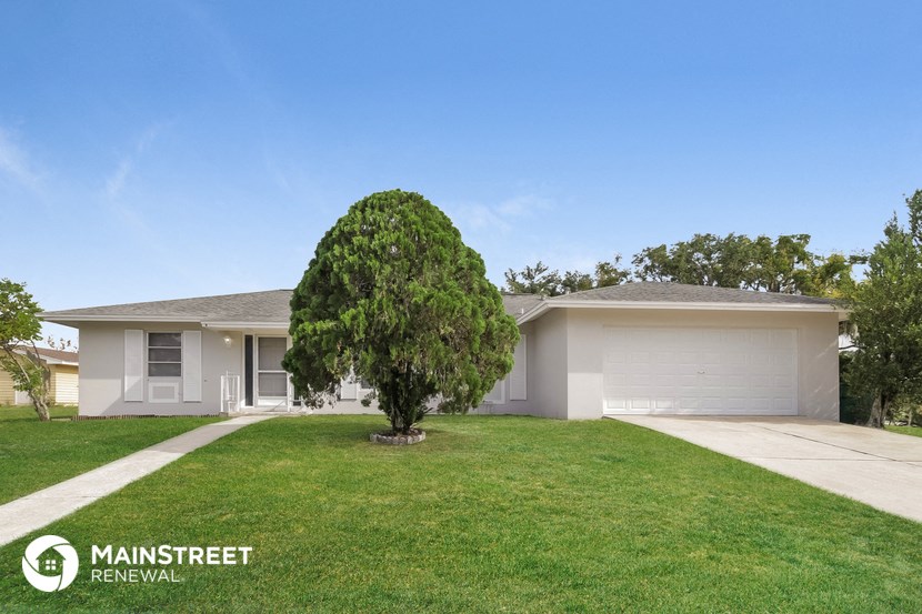 a house with a lawn and a tree in front of it