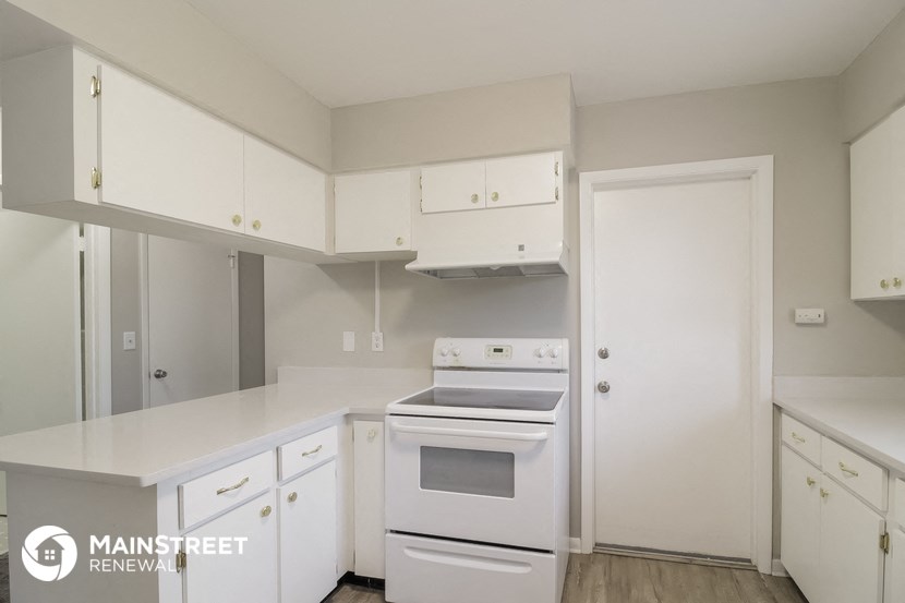 a white kitchen with white appliances and white cabinets