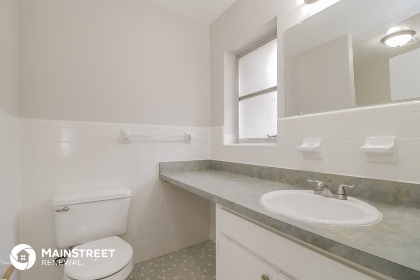 a white bathroom with a sink toilet and mirror