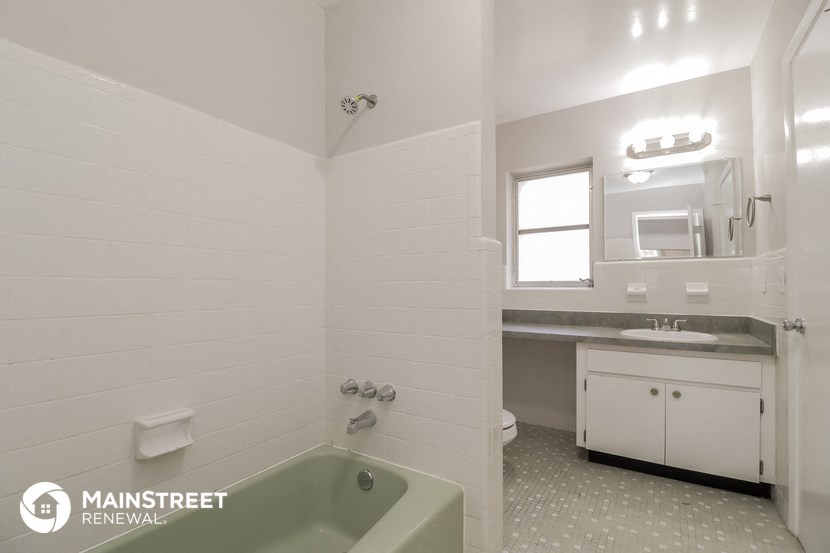 a bathroom with a tub and a sink and a mirror