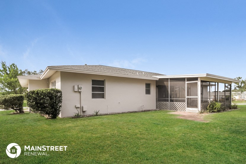 a small white house with a lawn and a porch