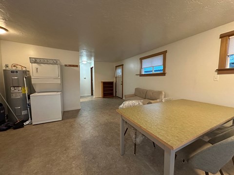 A kitchen area with a refrigerator, oven, and a table with chairs.