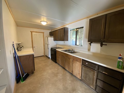 A kitchen with brown cabinets and a white fridge.
