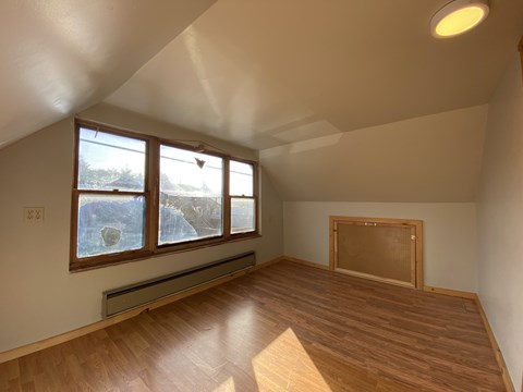 A room with wooden floors and a large window.