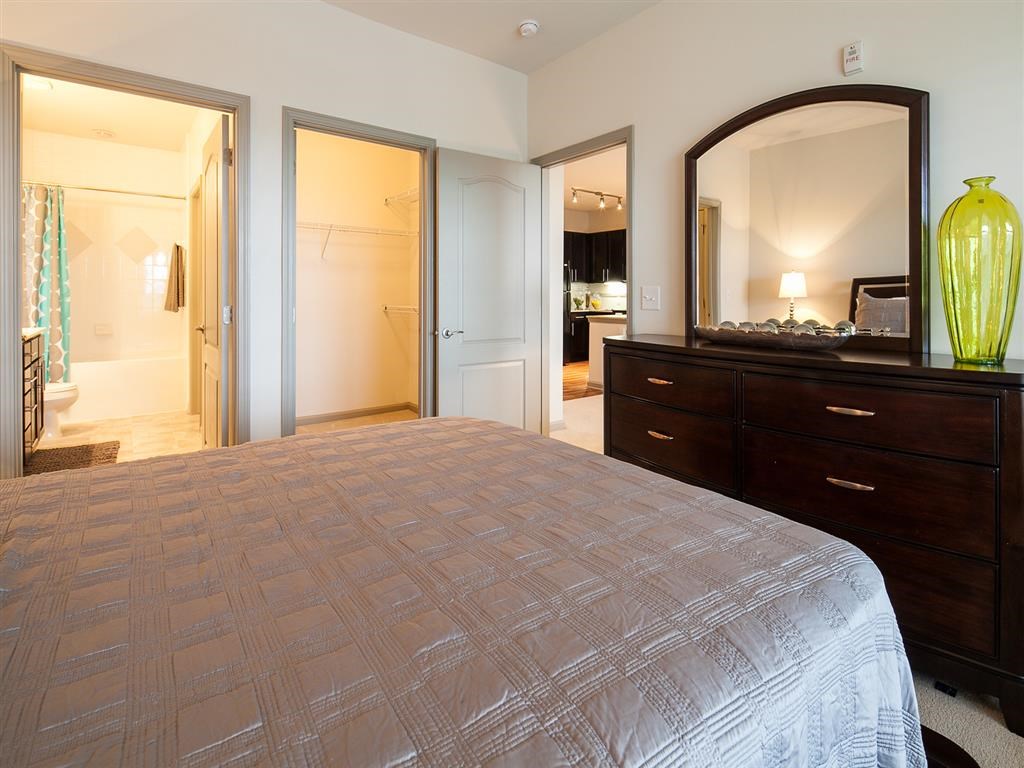 a bedroom with a large bed and a mirror