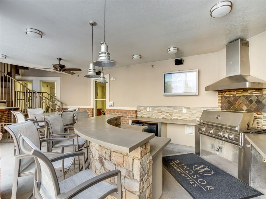 a clubhouse with a bar and chairs and a kitchen