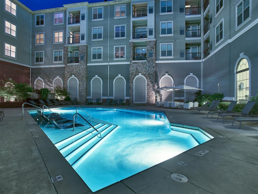 a swimming pool with an apartment building in the background