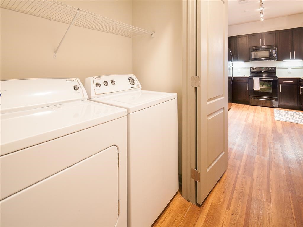 a white washer and dryer in a room with a kitchen
