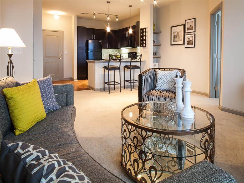 a living room and kitchen with a glass table