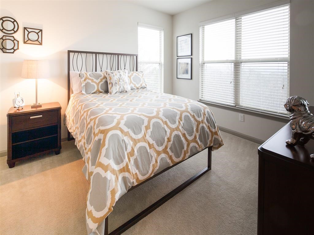 a bedroom with a bed and two windows