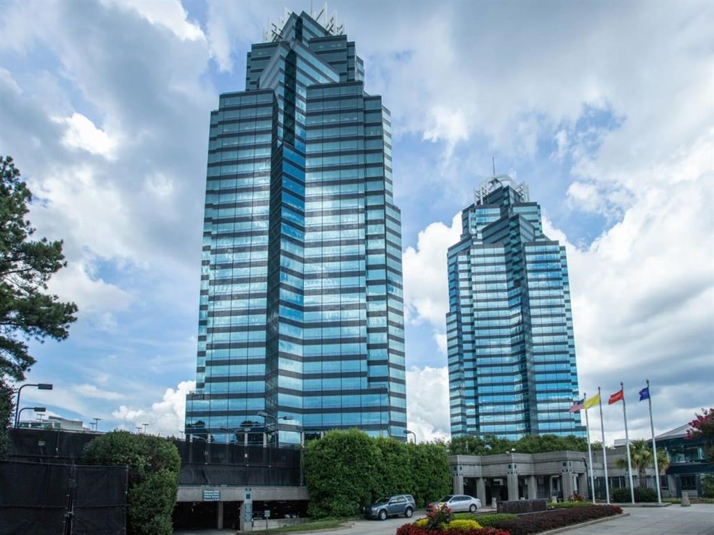 two tall buildings in front of a cloudy sky