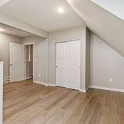 an empty living room with white walls and wood floors