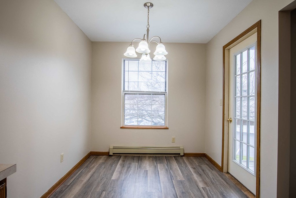 an empty living room with wood floors and a window