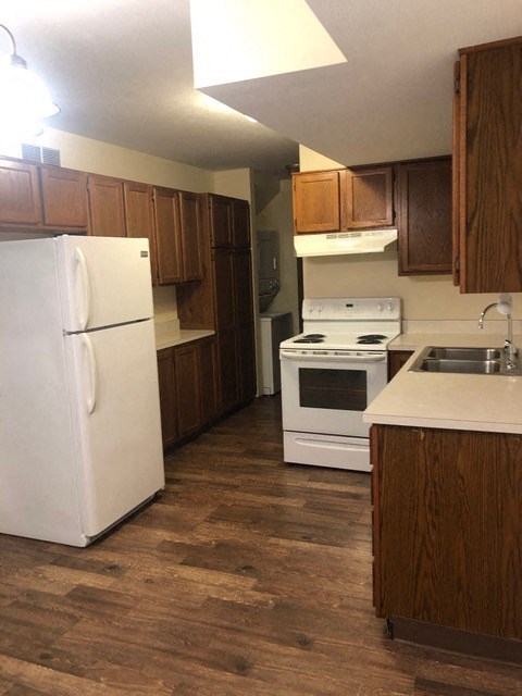 a kitchen with white appliances and wooden cabinets