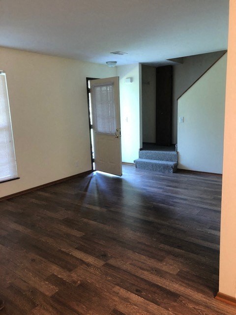 an empty living room with wood floors and a door