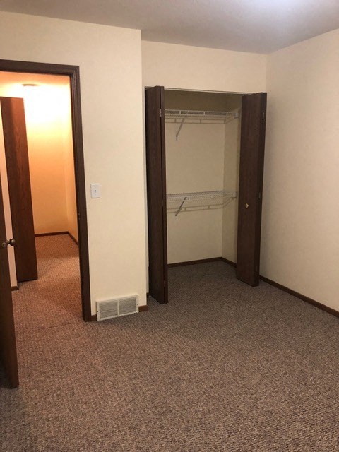 an empty room with a closet and a door open