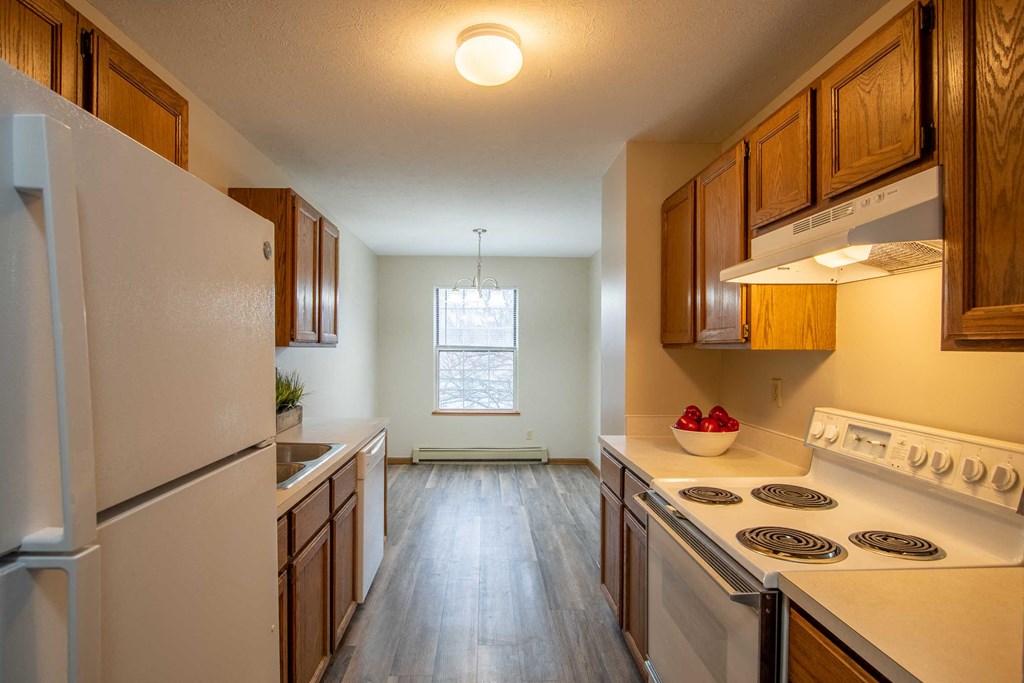 a kitchen with white appliances and wooden cabinets
