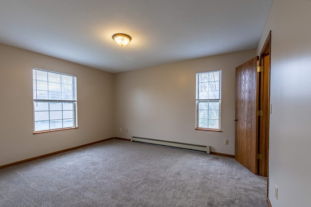 the master bedroom is spacious and has carpeted floors and two windows