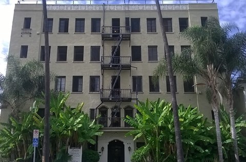 an old building with palm trees in front of it