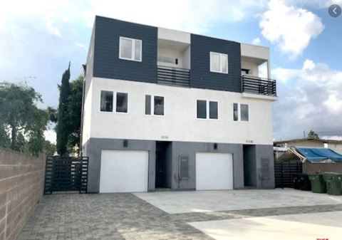 a white and black house with white garage doors