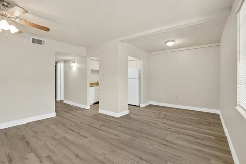 an empty living room with white walls and wood floors