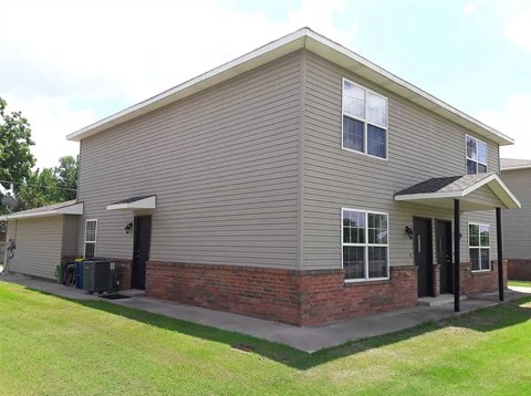 A house with a grey siding and a brick base.