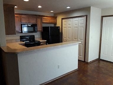 A kitchen with a black refrigerator and stove.