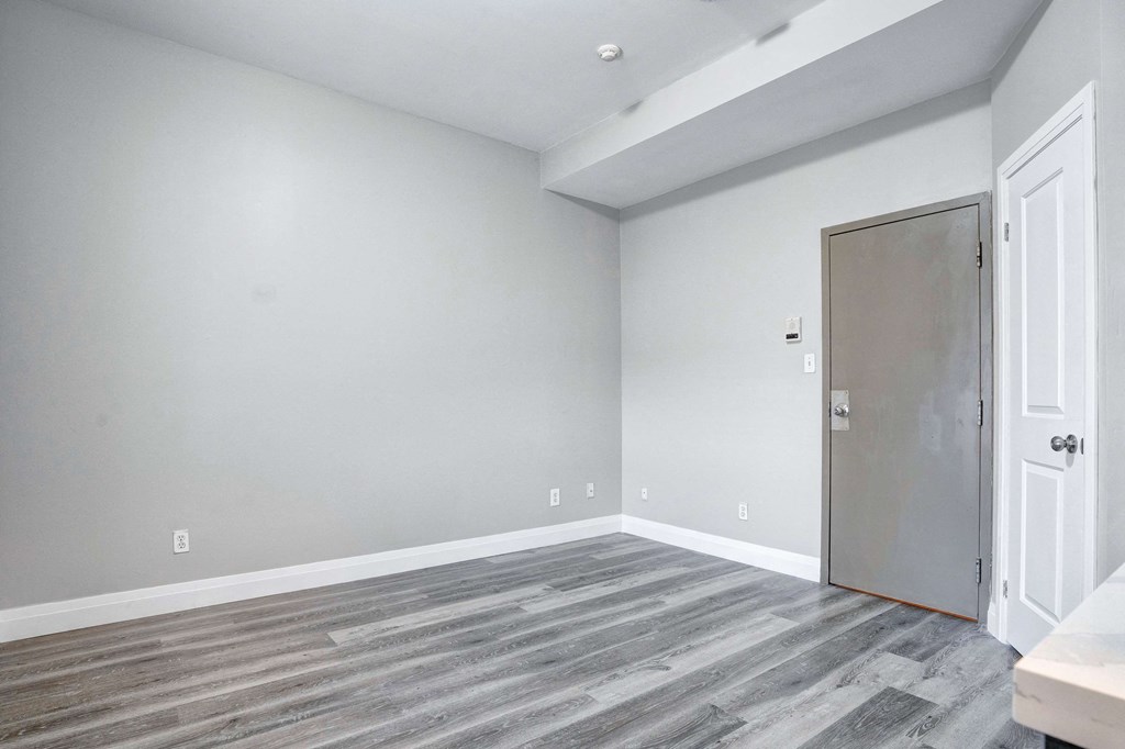 an empty room with grey walls and a door