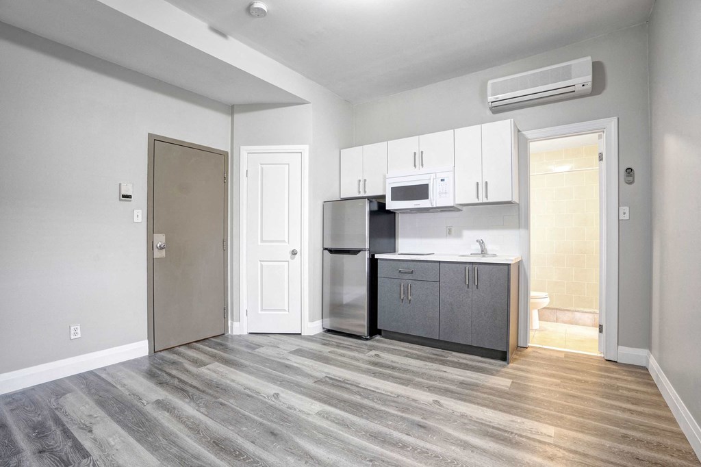 an empty room with a kitchen and a door