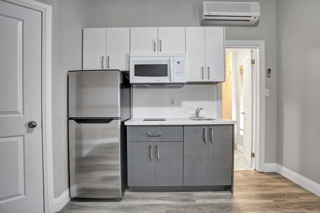 a small kitchen with stainless steel appliances and white cabinets