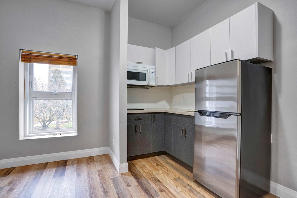 an empty kitchen with stainless steel appliances and white cabinets