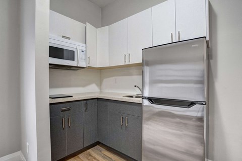 a kitchen with white cabinets and a stainless steel refrigerator