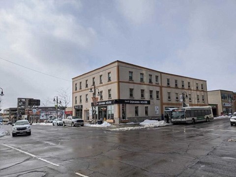 a building on a city street with cars and a bus