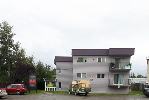a large apartment building with cars parked in front of it