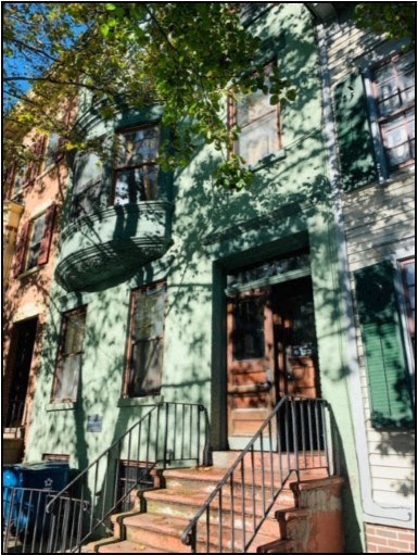 a house with stairs and a tree in front of it