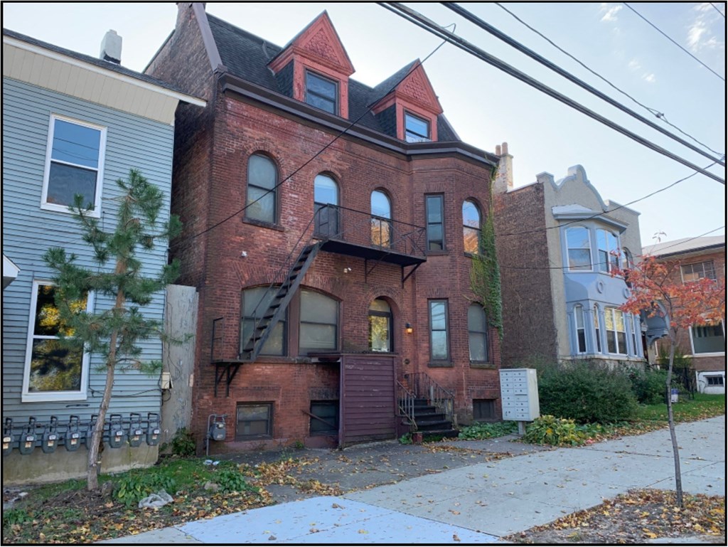 the front of a brick house with a staircase