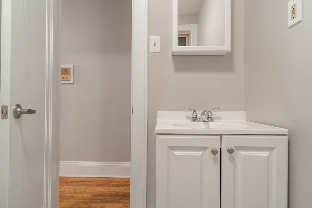 a bathroom with a sink and a mirror and a door